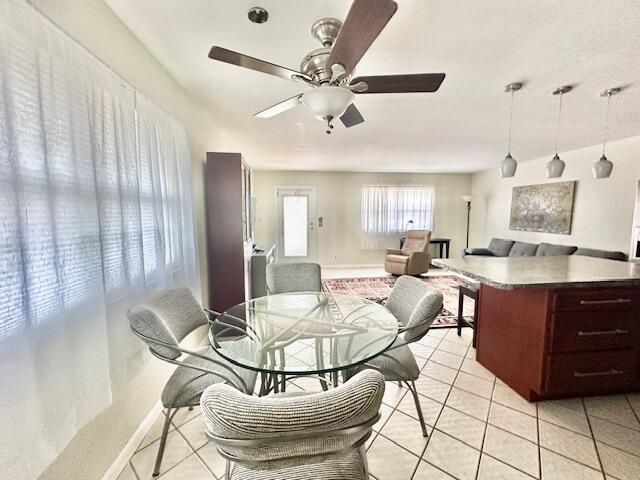 tiled dining area with ceiling fan