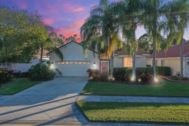 view of front of property with a yard and a garage