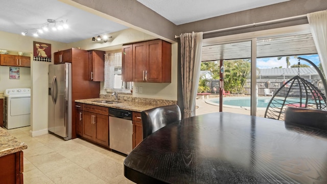 kitchen featuring washer / clothes dryer, appliances with stainless steel finishes, sink, and light stone counters