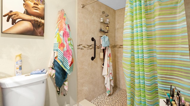 bathroom with curtained shower and toilet