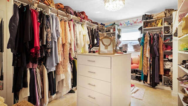 walk in closet with an inviting chandelier