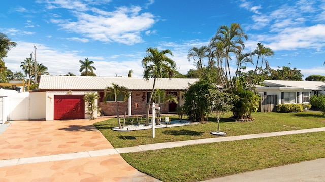 ranch-style house featuring a garage and a front yard