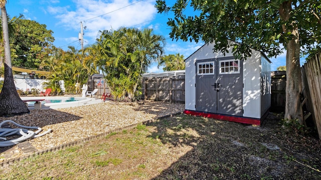 view of yard featuring a storage shed and a fenced in pool