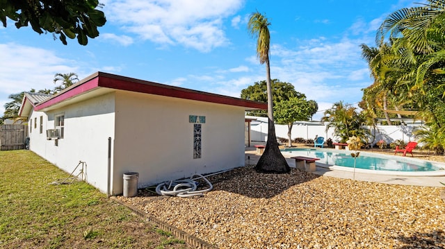 view of home's exterior featuring cooling unit and a fenced in pool