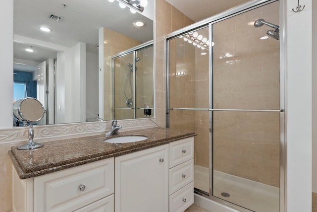 bathroom with walk in shower and vanity