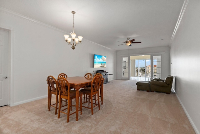 dining space featuring ornamental molding, ceiling fan with notable chandelier, and light carpet