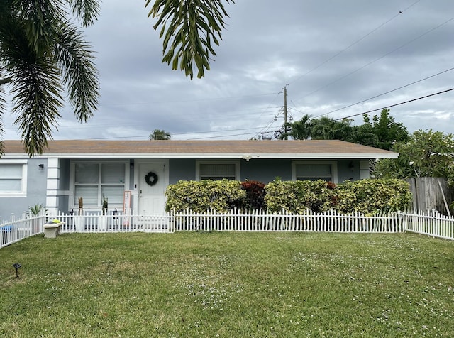 ranch-style house featuring a fenced front yard, stucco siding, and a front lawn