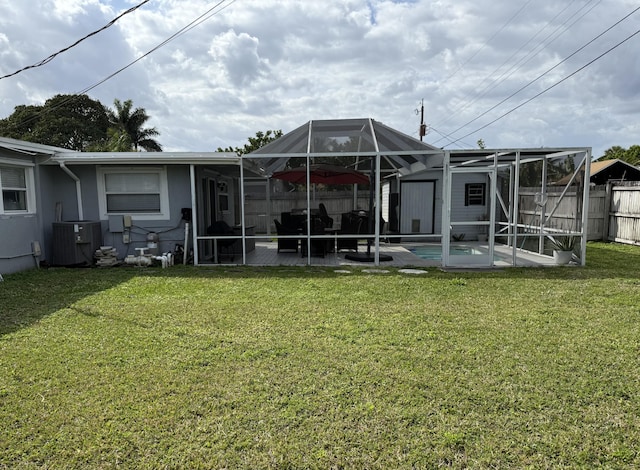 back of property with a fenced in pool, a lawn, glass enclosure, central AC, and fence