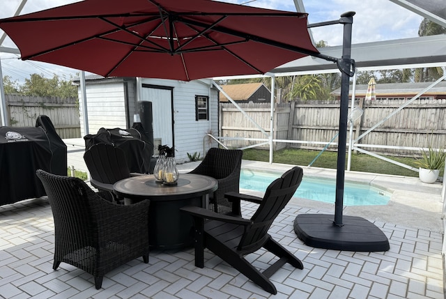 view of patio / terrace with glass enclosure, outdoor dining area, a fenced backyard, a grill, and a fenced in pool