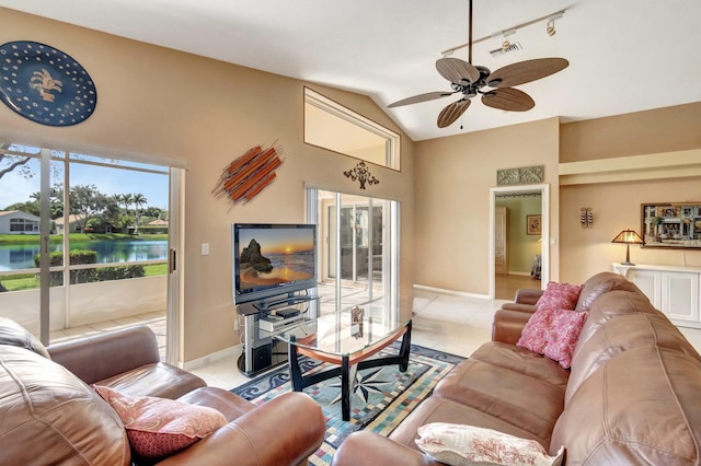 living room with vaulted ceiling, light tile patterned floors, track lighting, and ceiling fan