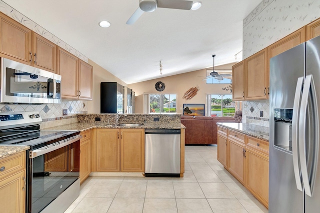 kitchen with vaulted ceiling, light tile patterned flooring, appliances with stainless steel finishes, sink, and ceiling fan