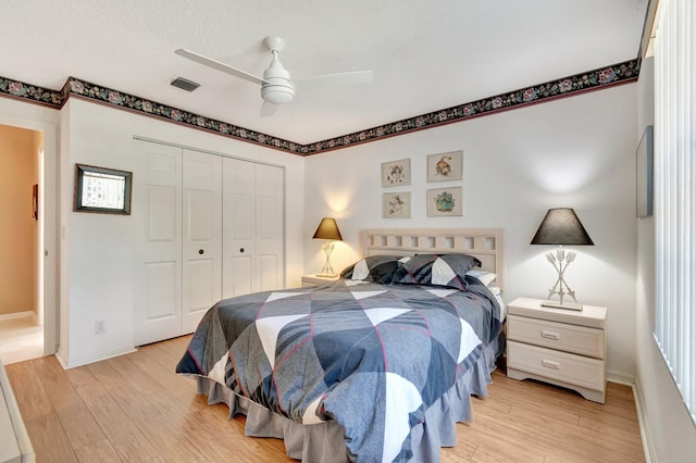 bedroom featuring ceiling fan, a closet, and light wood-type flooring