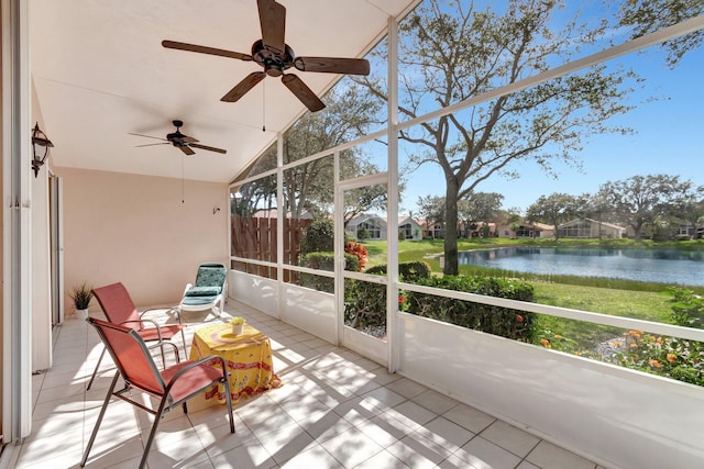 sunroom featuring a water view and lofted ceiling