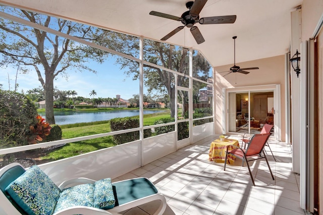 sunroom / solarium with a water view, ceiling fan, and vaulted ceiling