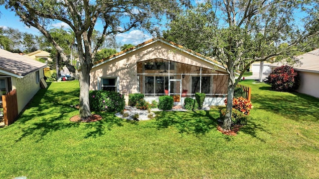 view of front of house featuring a sunroom and a front lawn