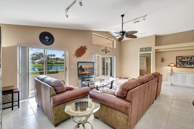 living room featuring light tile patterned floors, vaulted ceiling, rail lighting, and ceiling fan