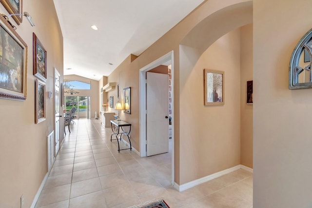 hall featuring vaulted ceiling and light tile patterned floors