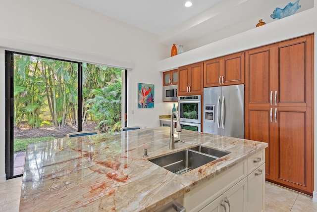 kitchen featuring sink, light tile patterned floors, stainless steel appliances, light stone counters, and white cabinets