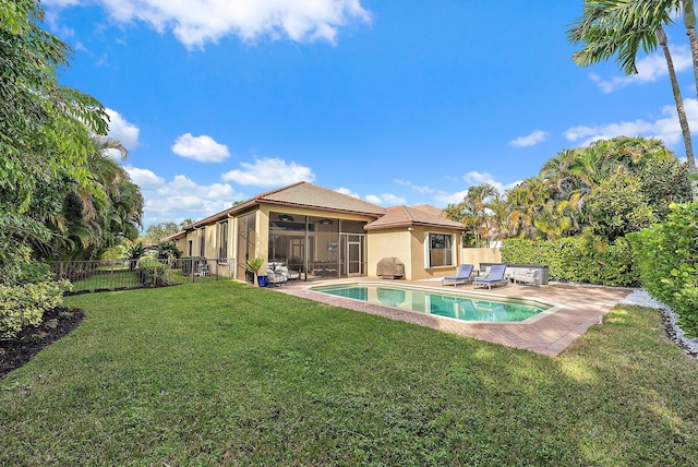 view of swimming pool featuring a patio, a yard, ceiling fan, a hot tub, and a sunroom