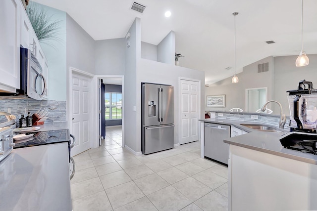 kitchen with white cabinets, lofted ceiling, decorative light fixtures, stainless steel appliances, and sink