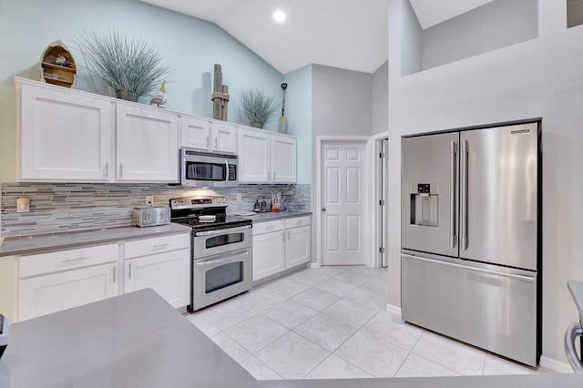 kitchen featuring appliances with stainless steel finishes, decorative backsplash, white cabinets, high vaulted ceiling, and light tile patterned flooring