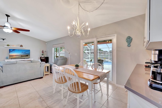 dining area with light tile patterned flooring, ceiling fan with notable chandelier, and lofted ceiling