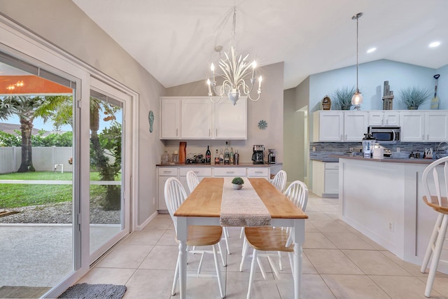 dining room featuring vaulted ceiling, a chandelier, and light tile patterned floors