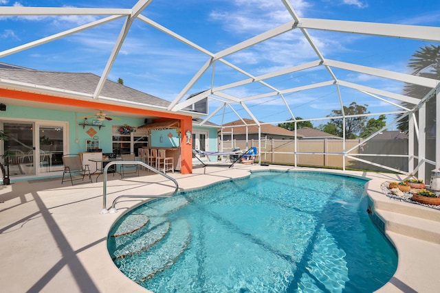 view of pool with a bar, a lanai, a patio area, and ceiling fan