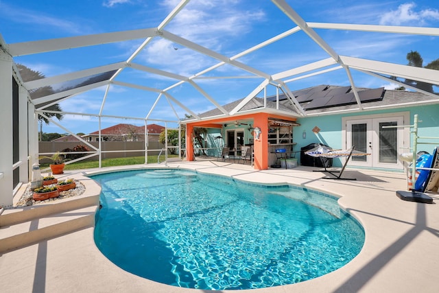 view of swimming pool with glass enclosure, french doors, and a patio area