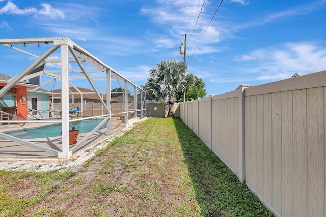 view of yard with glass enclosure and a fenced in pool