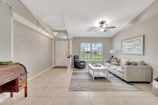 tiled living room featuring ceiling fan with notable chandelier and lofted ceiling