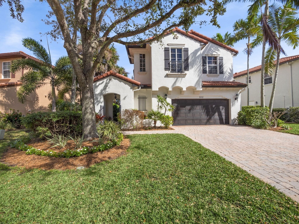 mediterranean / spanish home with a garage and a front yard