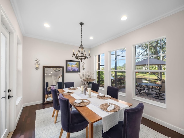 dining room featuring dark wood-type flooring, ornamental molding, and an inviting chandelier