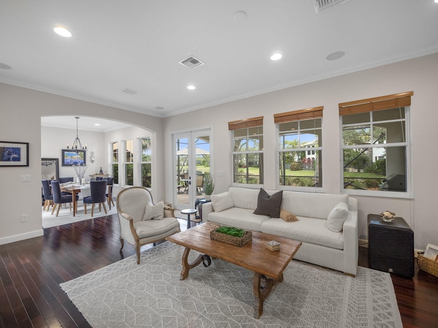 living room with dark wood-type flooring, ornamental molding, and french doors