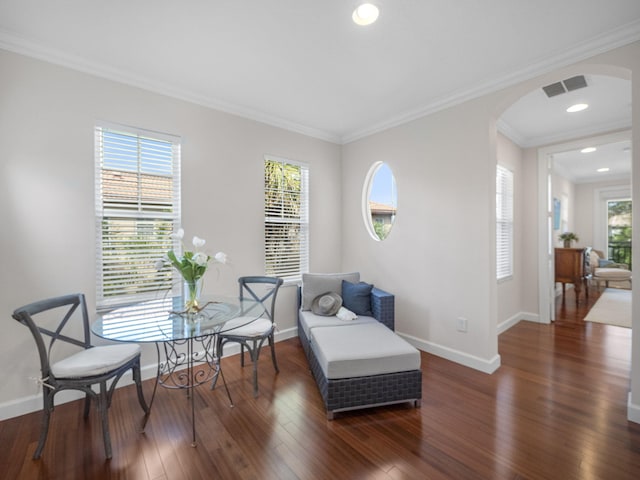 sitting room with dark wood-type flooring, ornamental molding, and a wealth of natural light