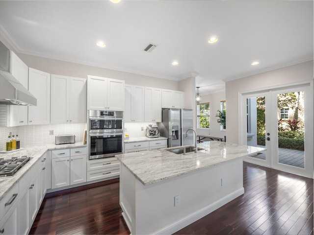 kitchen featuring appliances with stainless steel finishes, an island with sink, sink, white cabinets, and crown molding