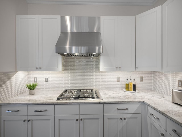 kitchen with white cabinetry, light stone counters, tasteful backsplash, stainless steel gas cooktop, and exhaust hood