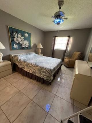 tiled bedroom with ceiling fan and a textured ceiling