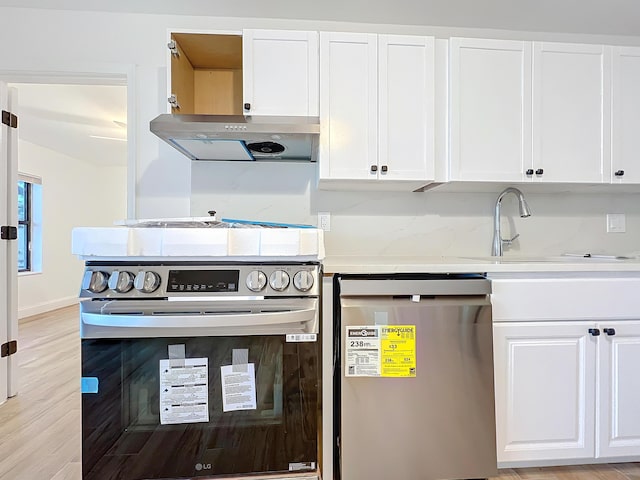 kitchen featuring white cabinetry, dishwashing machine, and stainless steel electric range oven