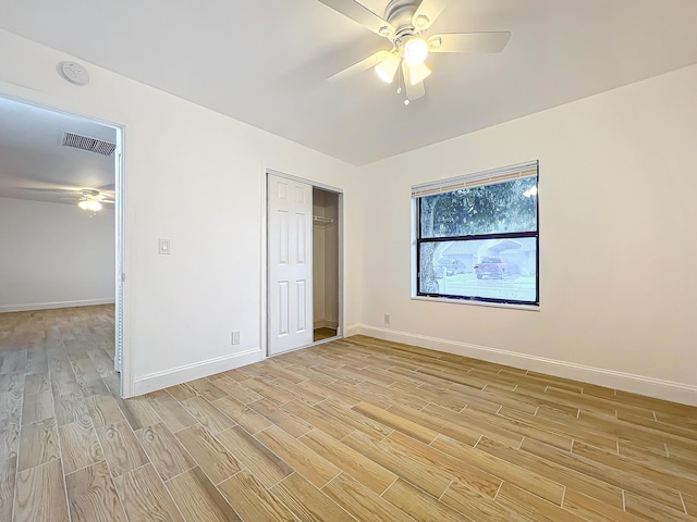 unfurnished bedroom featuring ceiling fan, a closet, and light hardwood / wood-style flooring