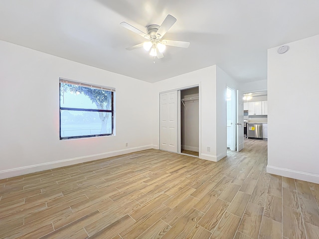 unfurnished bedroom featuring ceiling fan, a closet, and light hardwood / wood-style flooring