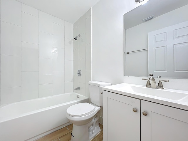 full bathroom with toilet, tiled shower / bath, and vanity