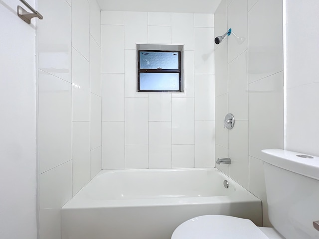 bathroom with toilet and tiled shower / bath combo