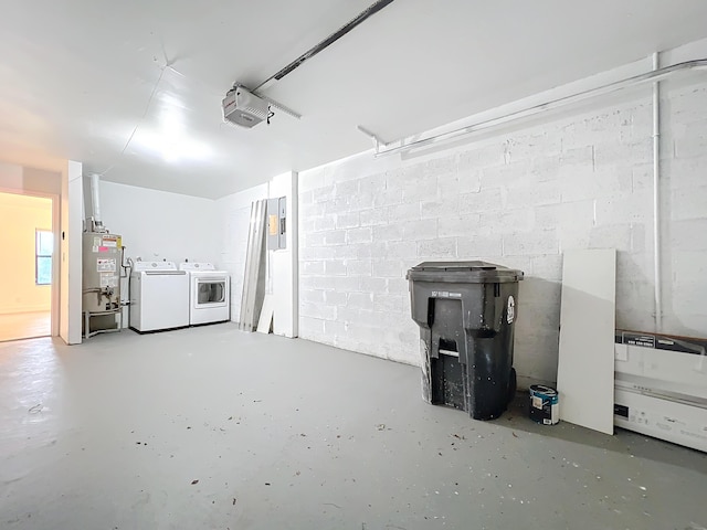 garage featuring gas water heater, independent washer and dryer, and a garage door opener