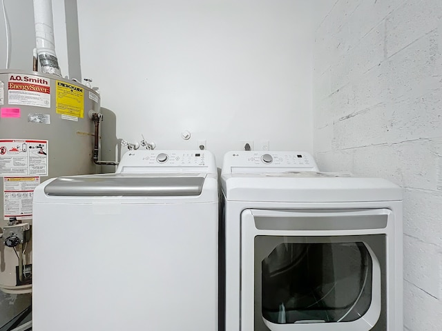 laundry area featuring water heater and independent washer and dryer