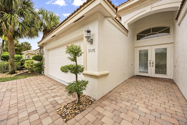 doorway to property with a garage and french doors