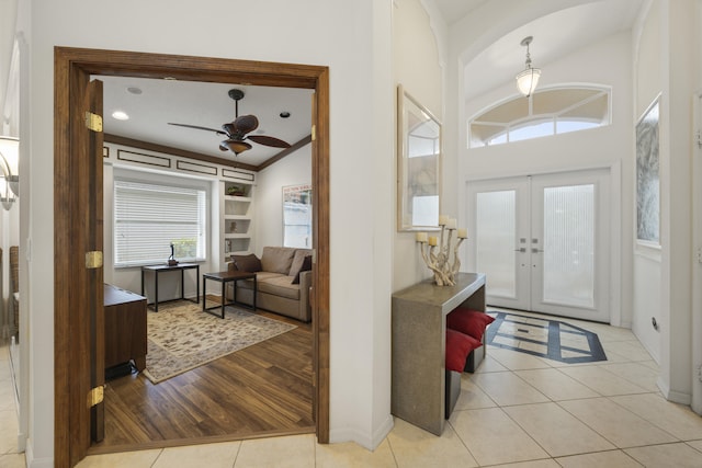 foyer featuring plenty of natural light, light tile patterned floors, lofted ceiling, and french doors