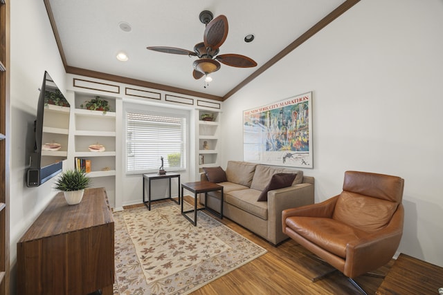 living room with ceiling fan, light wood-type flooring, ornamental molding, built in features, and vaulted ceiling