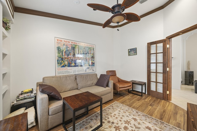 living room featuring light hardwood / wood-style floors, french doors, ornamental molding, and ceiling fan