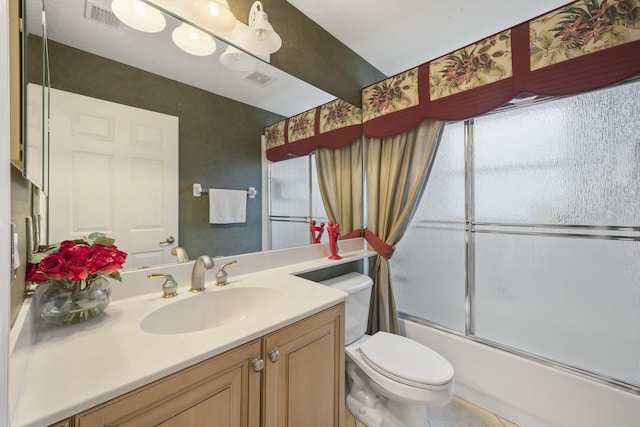 full bathroom featuring enclosed tub / shower combo, vanity, and toilet